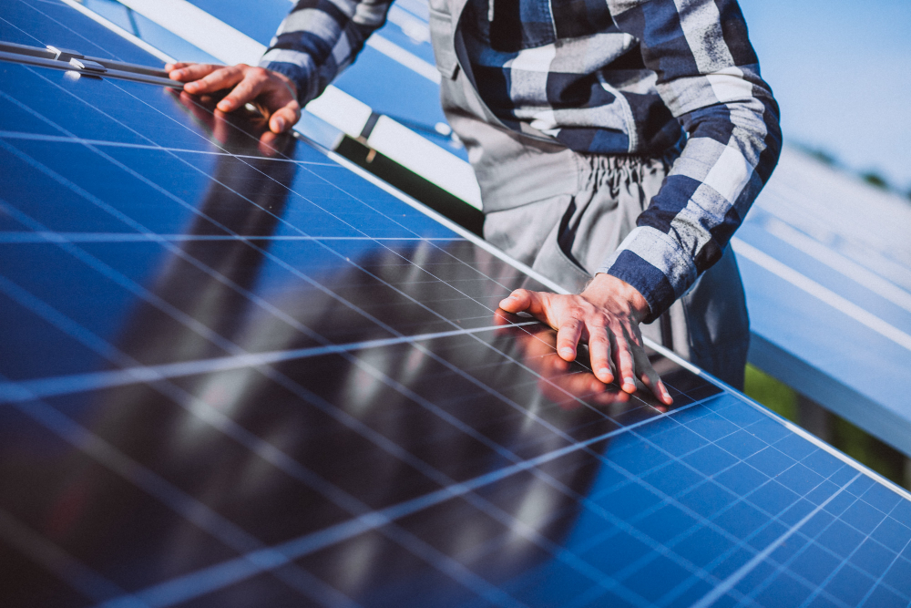 Un homme posant des panneaux solaire sur un toit